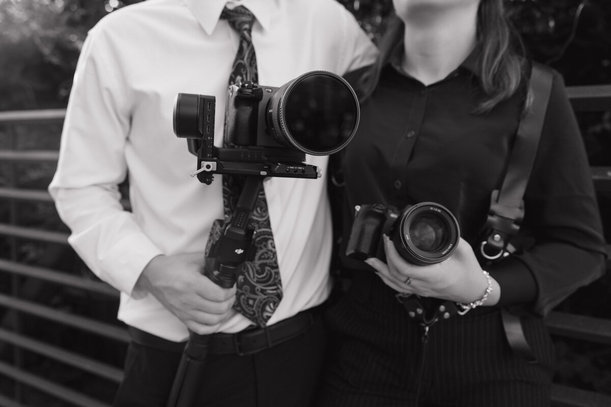 Wedding Photo and Video Duo showing their cameras in Depot park in Kennesaw.