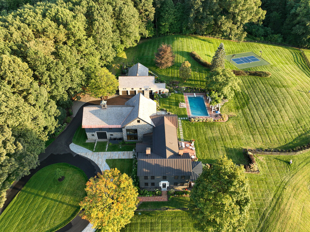 drone view of white house with green manicured lawn
