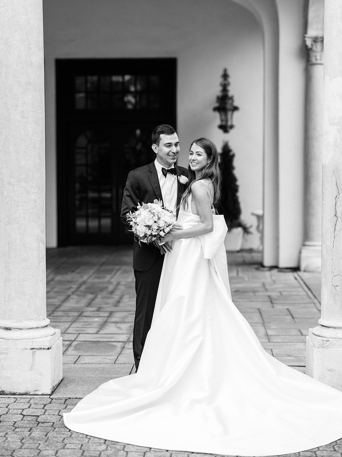 A black and white photo of a bride and groom in front of congressional country club