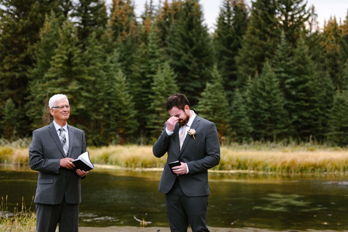 A groom crying when seeing his bride walk down the aisle during their wedding at Schwabacher Landing