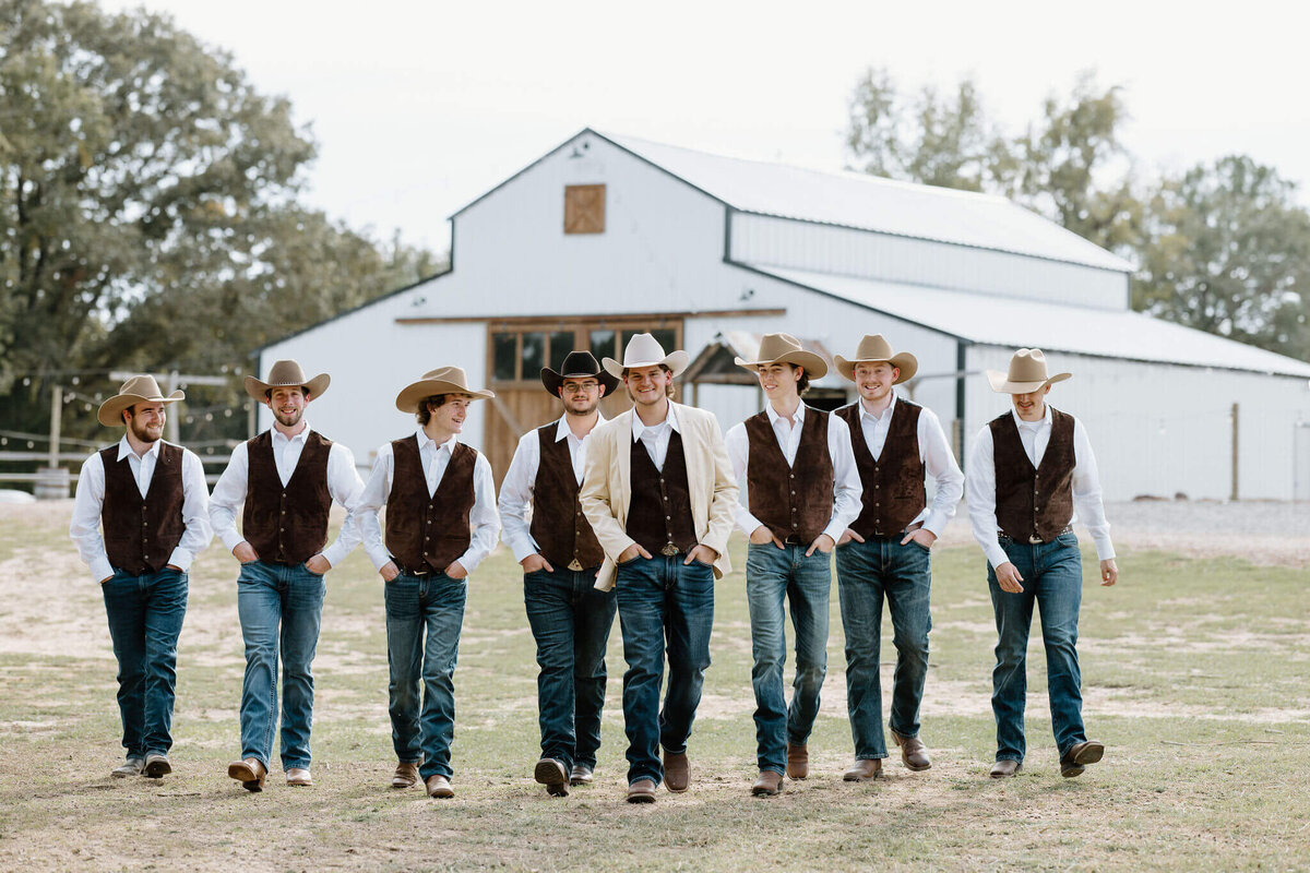 Candid portrait of groom and groomsmen walking in front of Shadow Ranch on wedding day