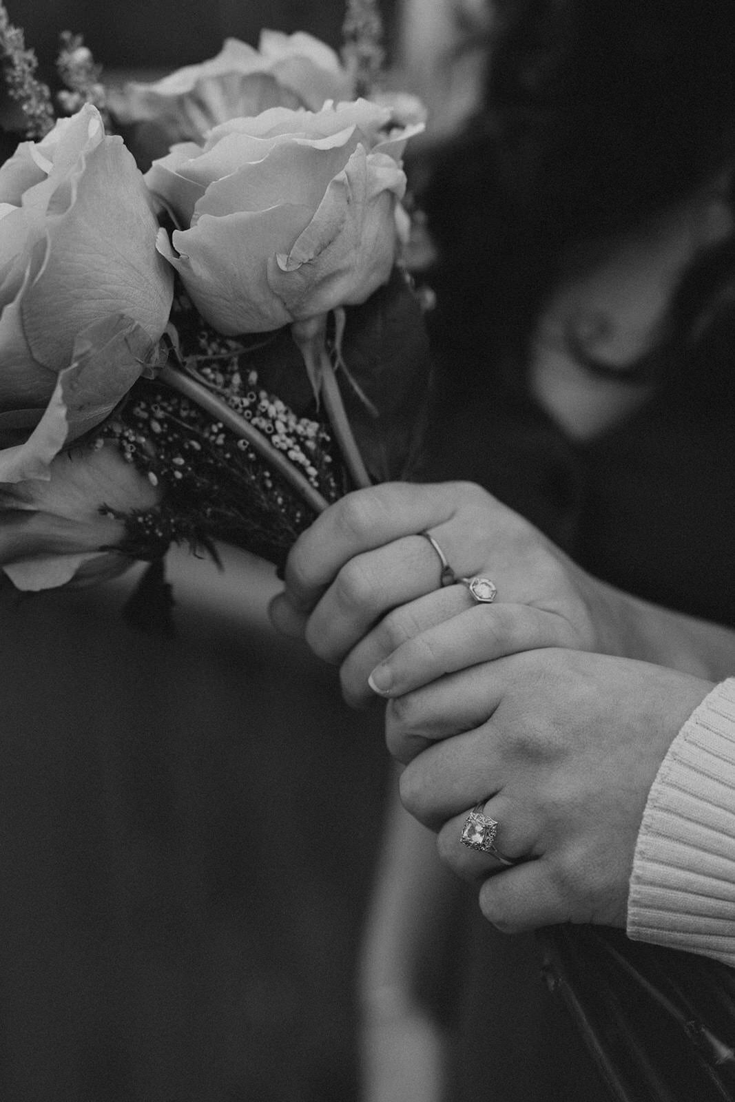 Two women hold their wedding bouquet with their new rings on their fingers 