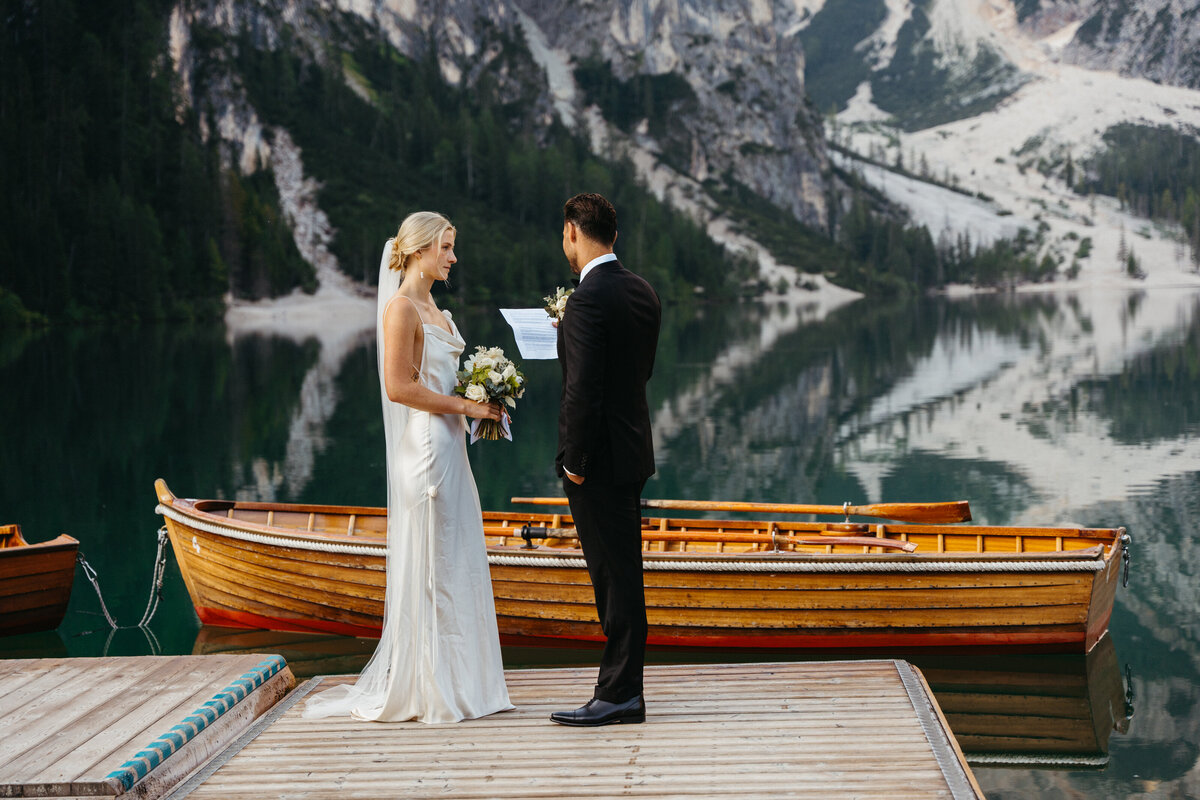 Bride smiling as groom reads vows at Dolomites elopement