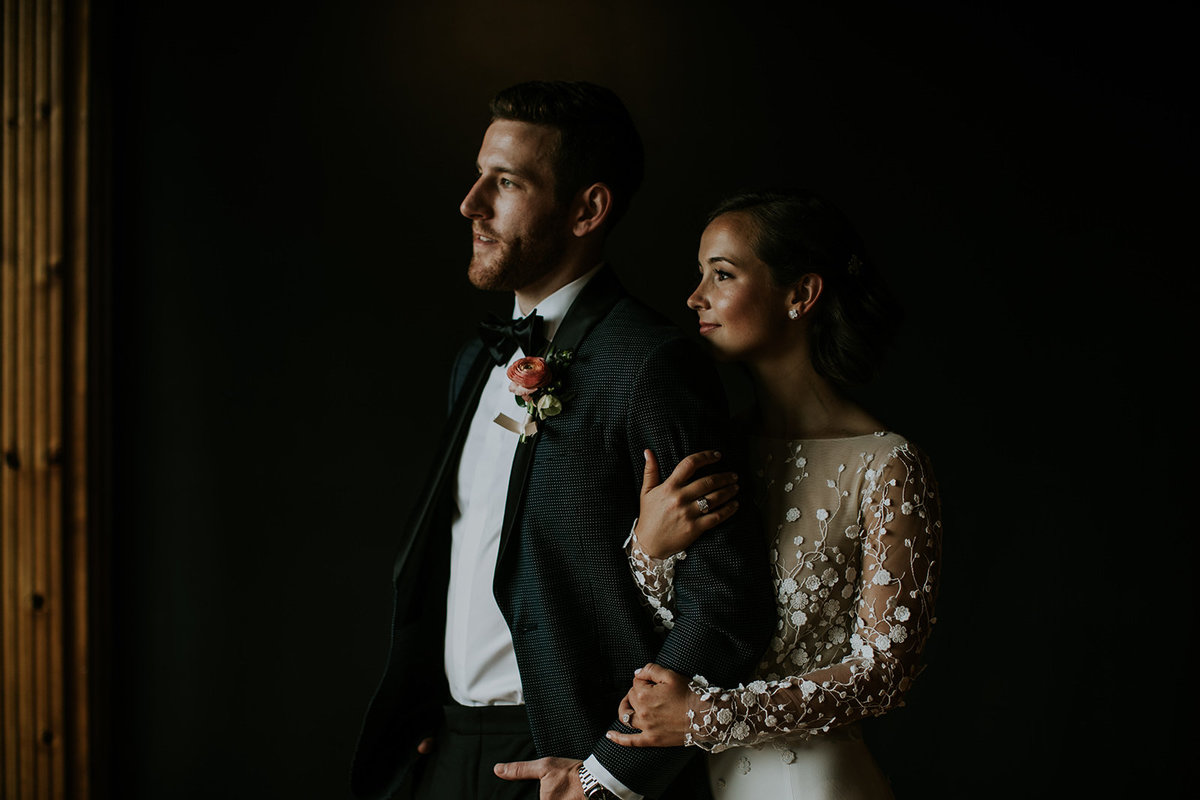 Wedding bride and groom looking out window of Mavris in Indianapolis Indiana before their wedding