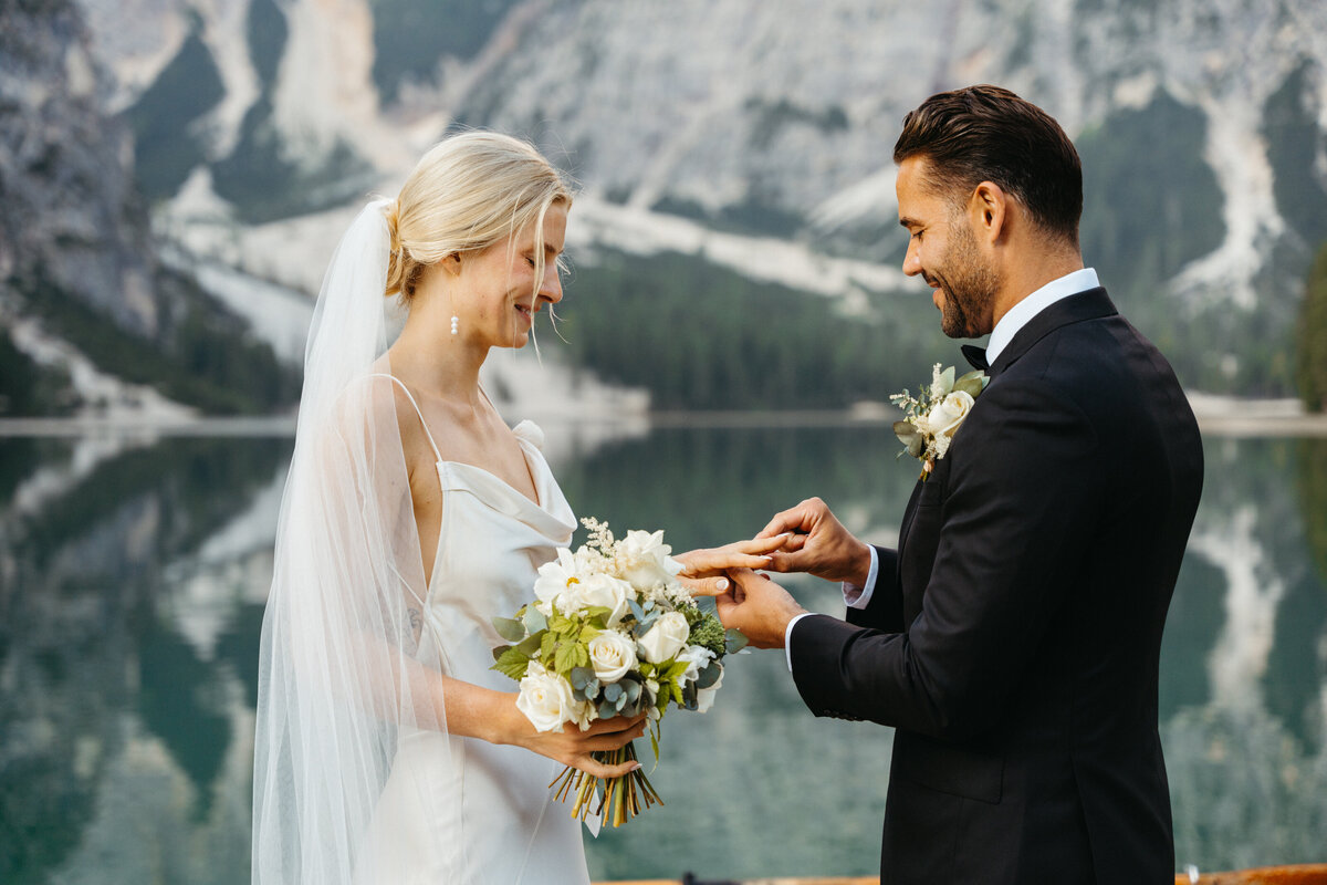 Groom placing ring on bride’s hand