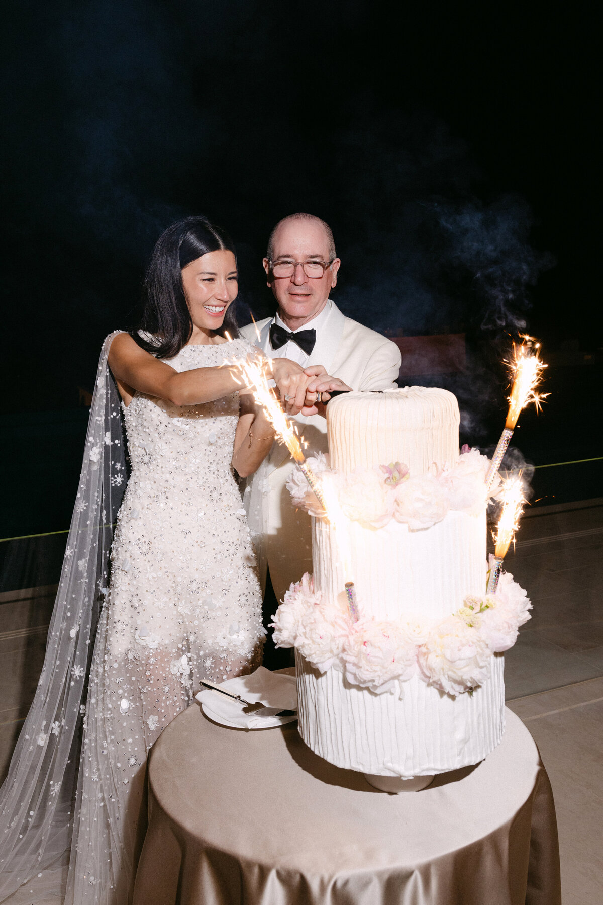 Elegant married Couple cutting wedding cake at their Luxury wedding French Riviera at le Grand Hotel du Cap Ferrat, A Four Seasons Hotel