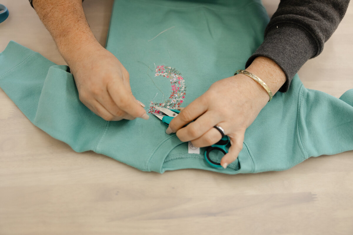 Rows of colorful embroidery thread spools neatly organized on display. Photograph by Yucaipa branding photographer Kaitlyn Dawn Photography.
