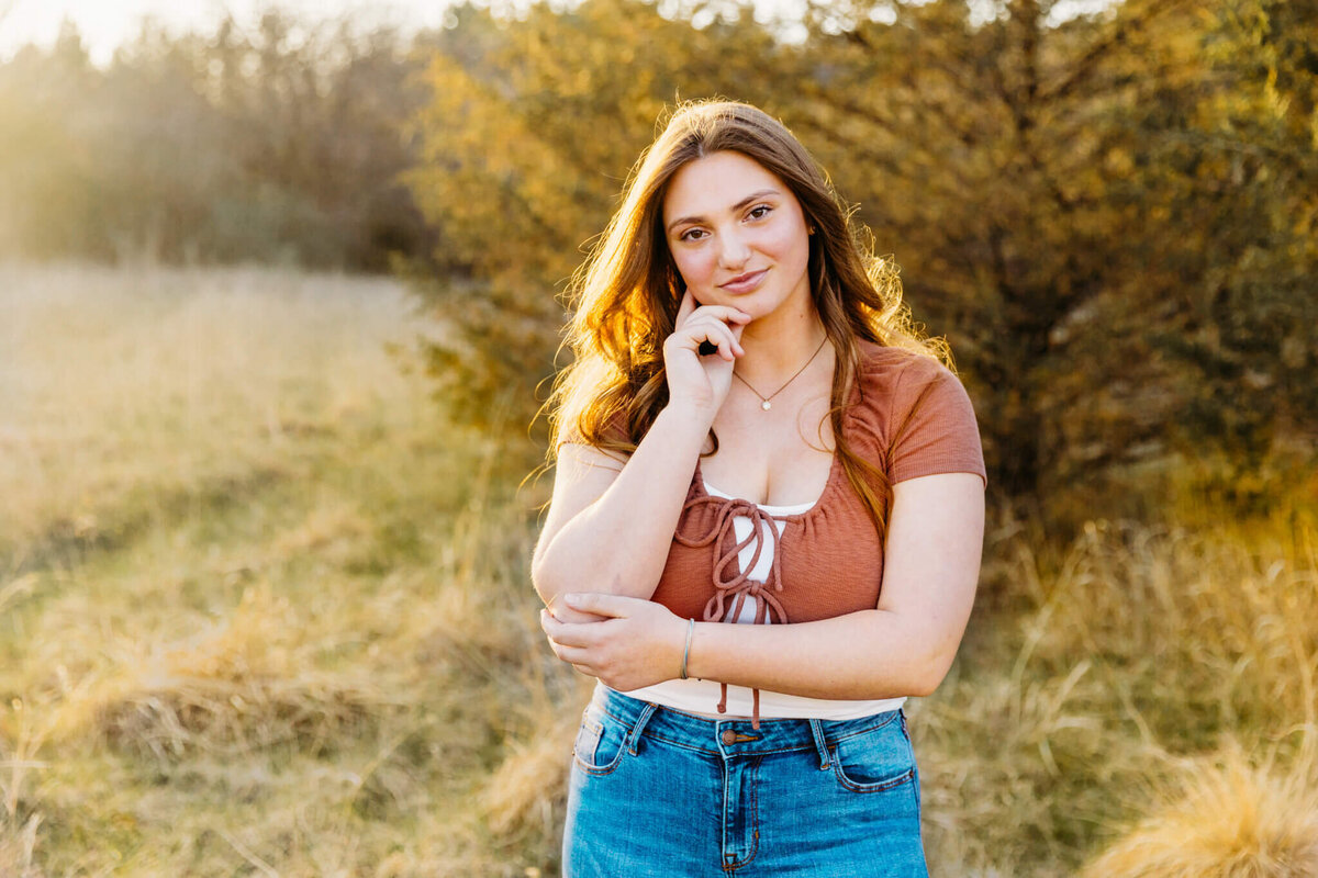 high school senior girl in  posing in a field near Oshkosh