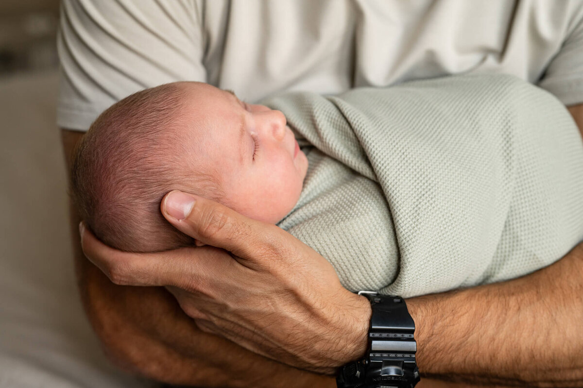 Dad holding newborn up close shot