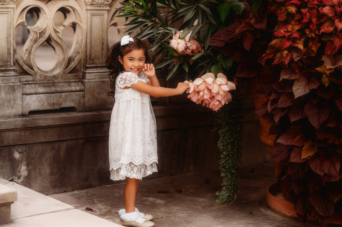 Little girl giggles at the camera during Family Pictures at Biltmore Estate in Asheville, NC.