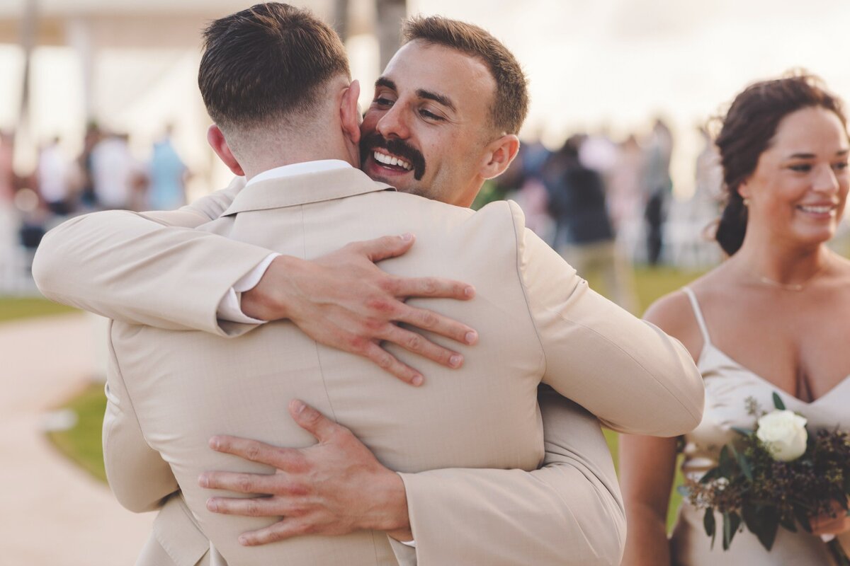 Groomsman congratulating groom after wedding in Cancun