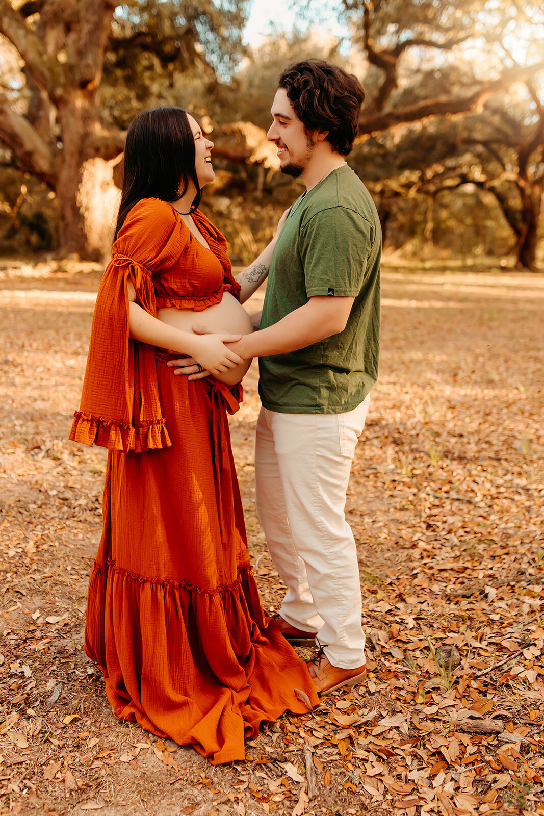 Tarkington TX maternity portraits—expecting couple holding hands face to face outdoors