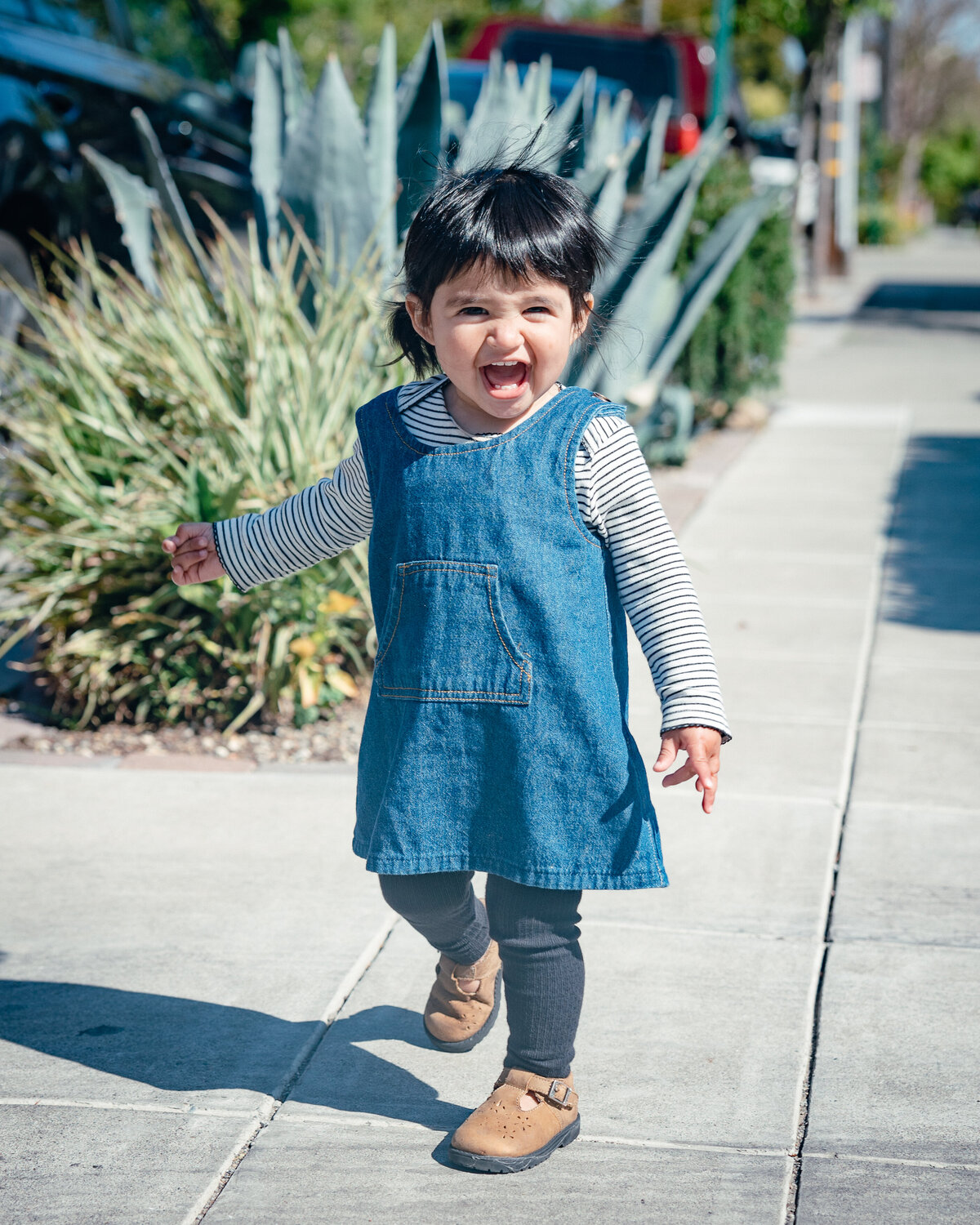 Toddler smiles as she walks down the street