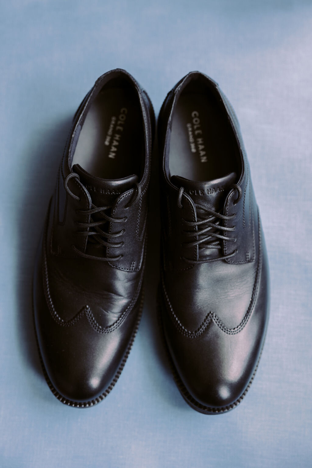 groom shoes on a blue flat lay backdrop