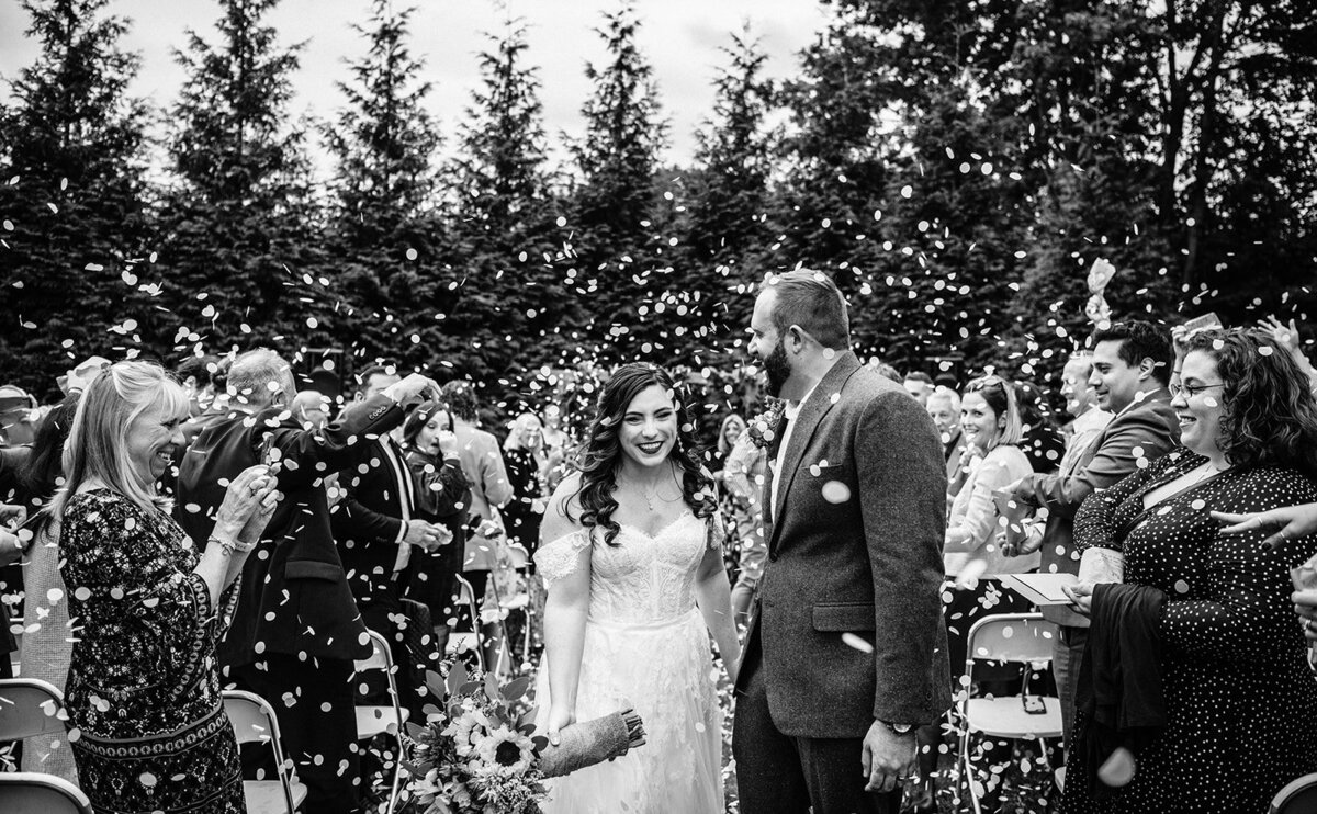 confetti flies around bride and groom after their wedding ceremony photo by cait fletcher photography