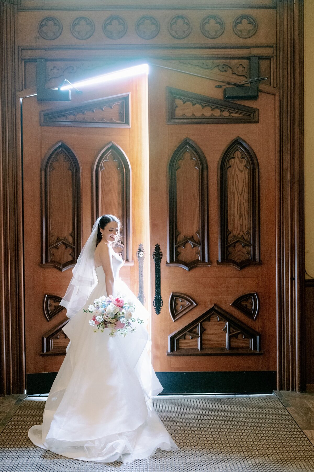 bride posing near the doors of a Catholic church