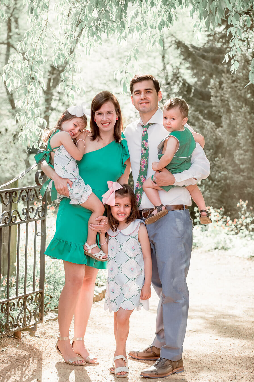 a family standing and holding their kids posing for a photo