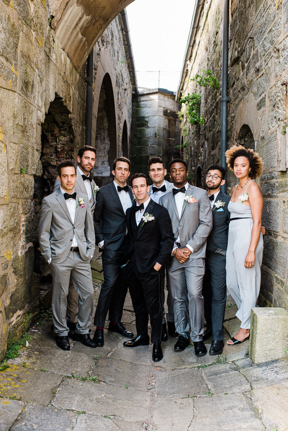 serious wedding party portrait in stone alley