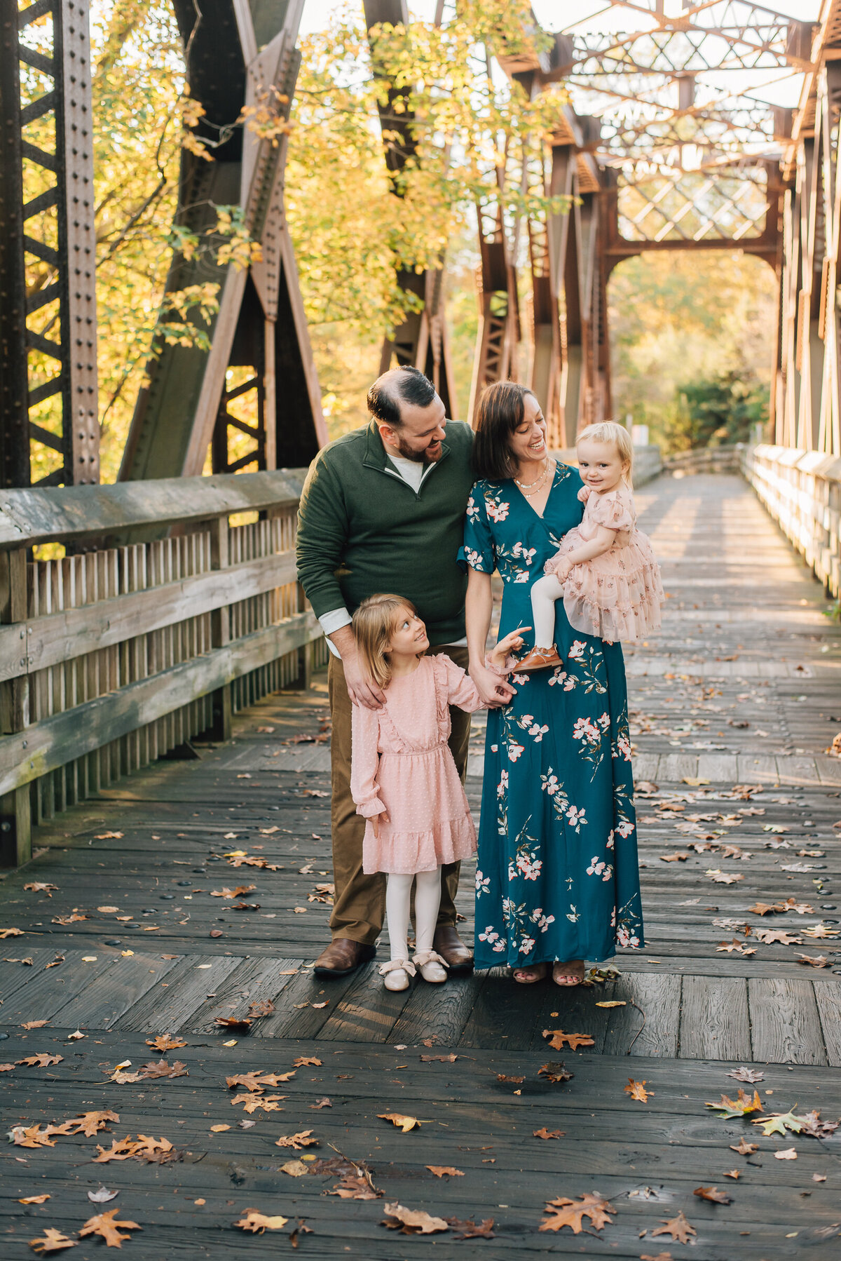 A family of four on a bridge in downtown Collinsville at their family photo shoot with Sharon Leger Photography.