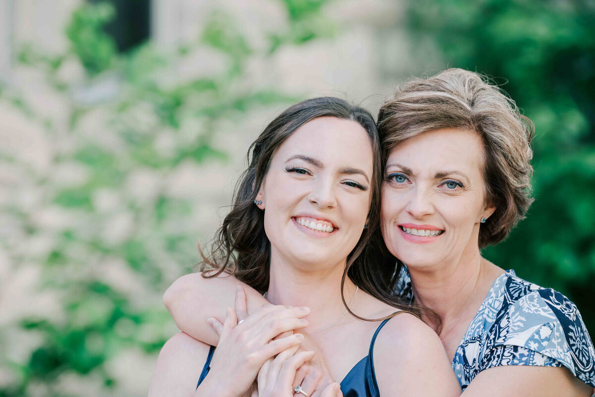 Close up of mom and daughter. Mom's arms wrapped around her. 