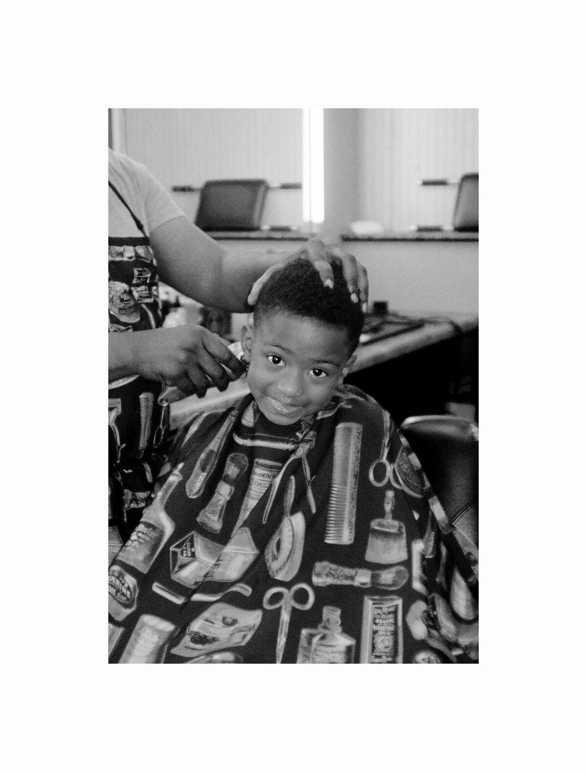 Child getting a haircut in a black barbershop
