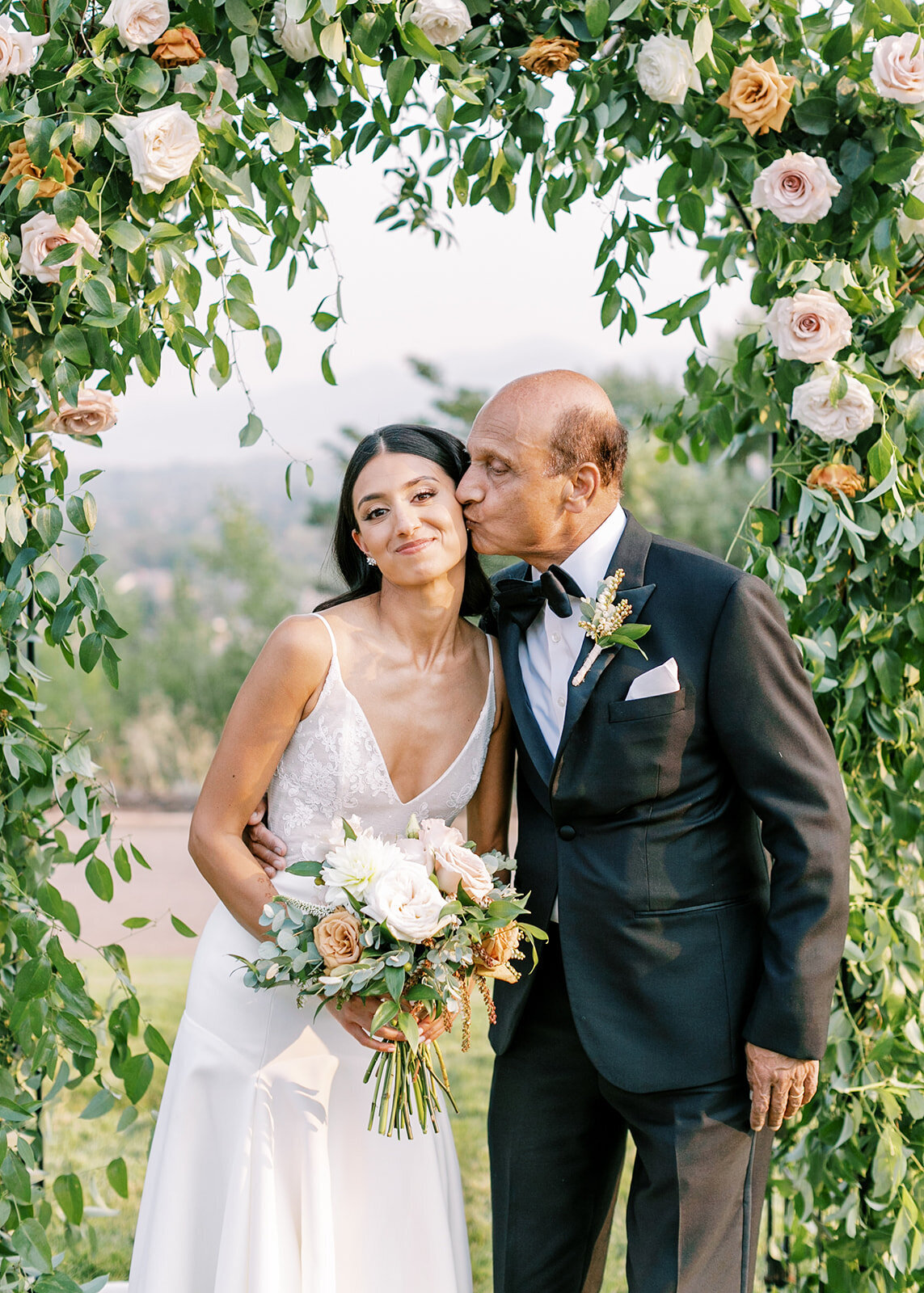 Bride and groom under a custom wedding floral arch