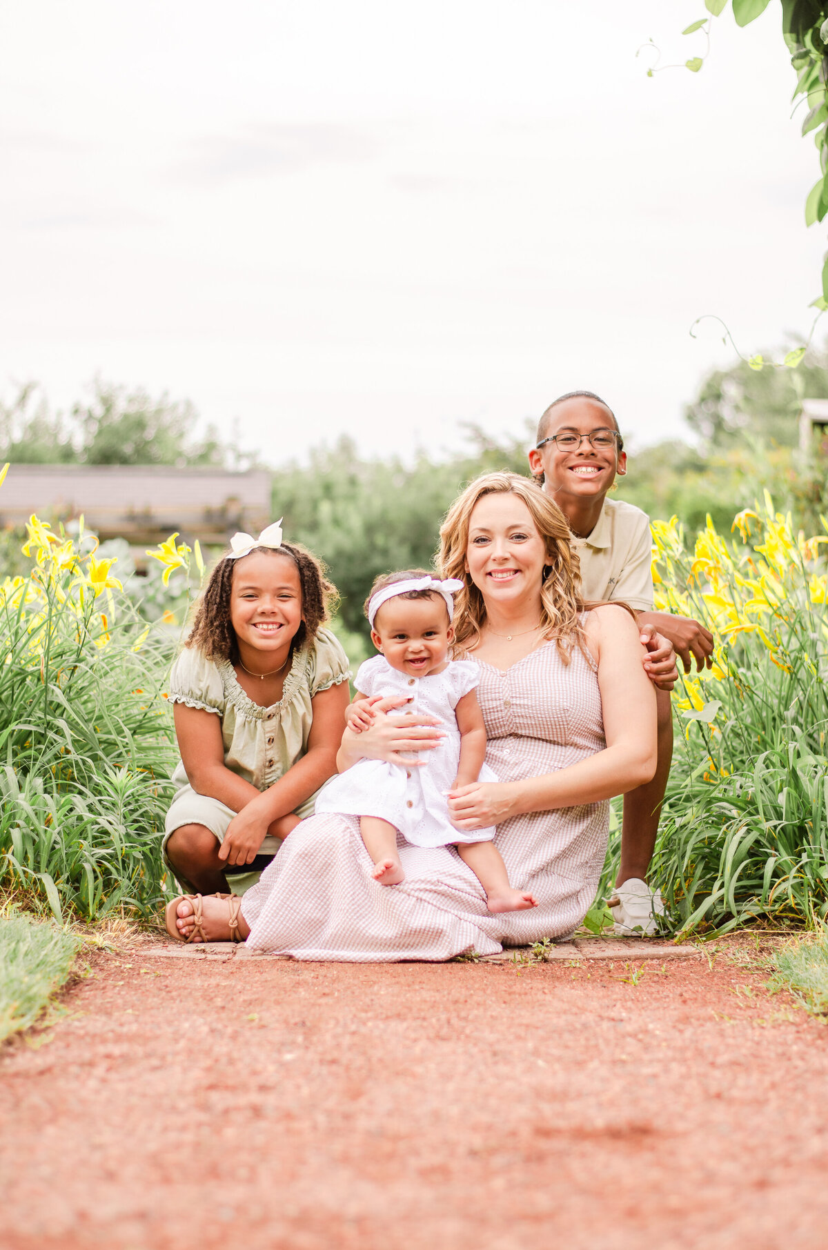 family poses together in flower field