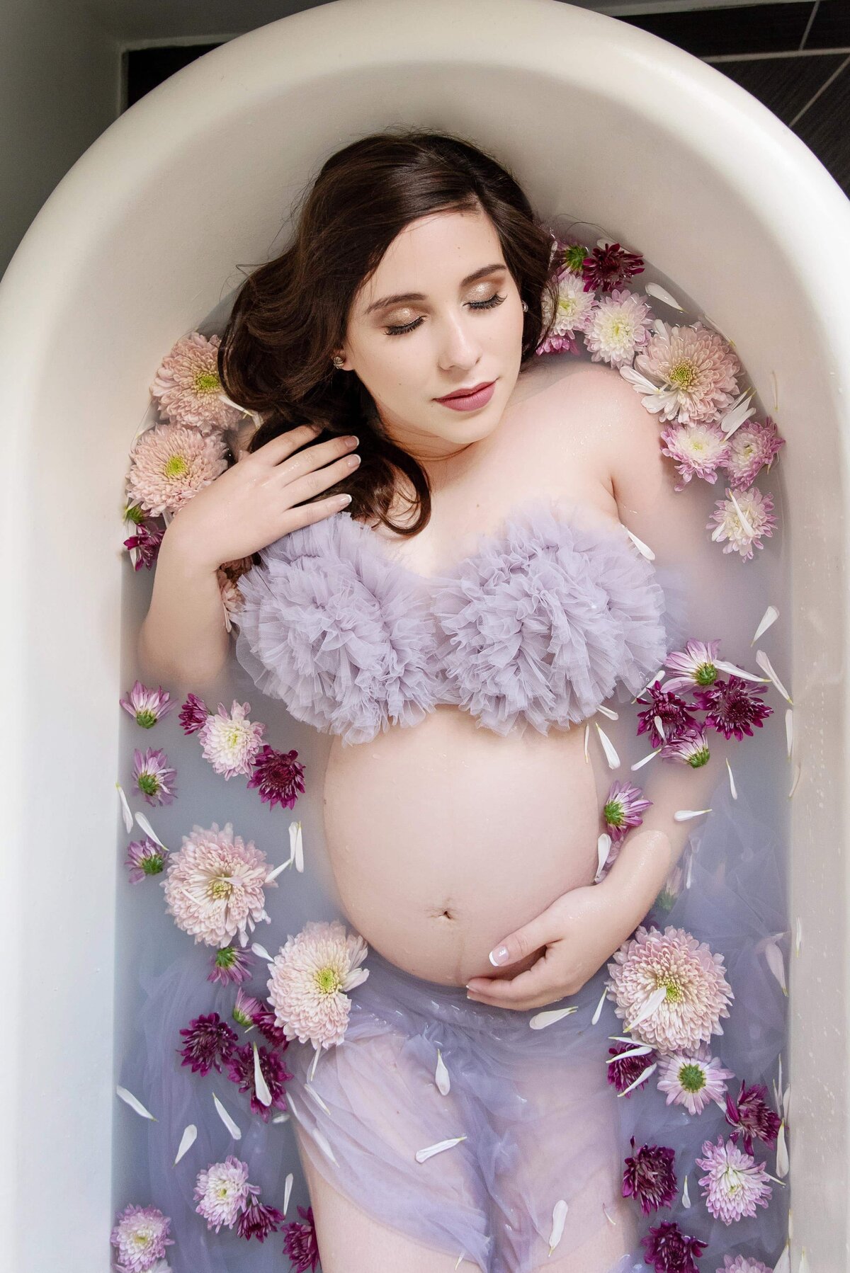 st-louis-maternity-photographer-pregnant-mom-wearing-purple-ruffle-top-in-milk-bath-with-purple-flowers