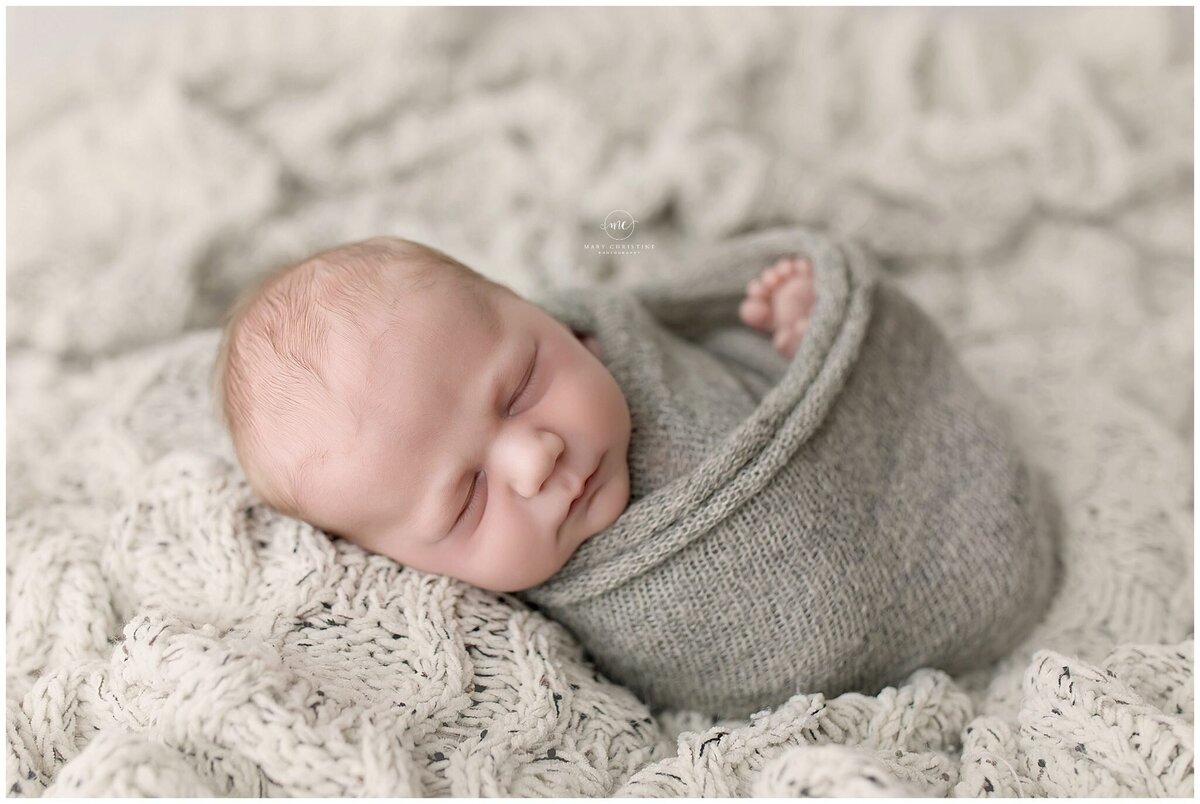 cozy swaddle newborn for a photo session in Akron studio