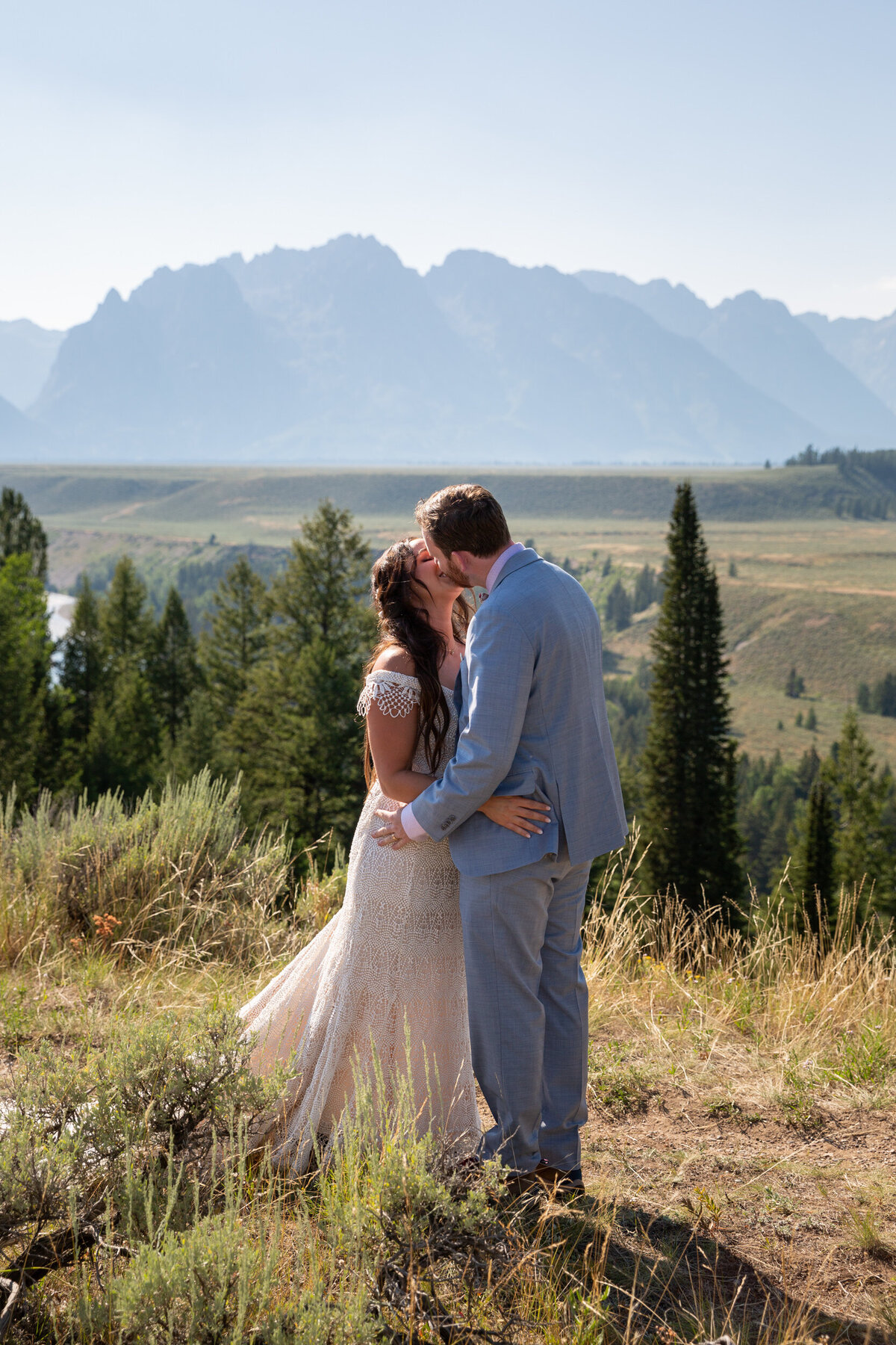 A bride and groom kiss as their Wyoming elopement photographer takes their picture.