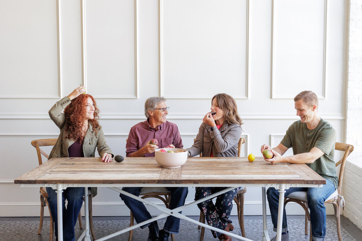 Photo of team sitting at table with fruit