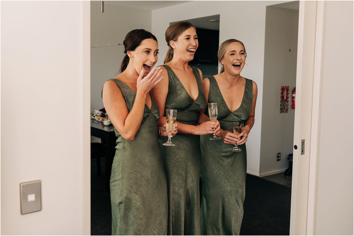 bridesmaids in green dresses from showpo with champagne at clearwater resort in christchurch seeing bride and excited