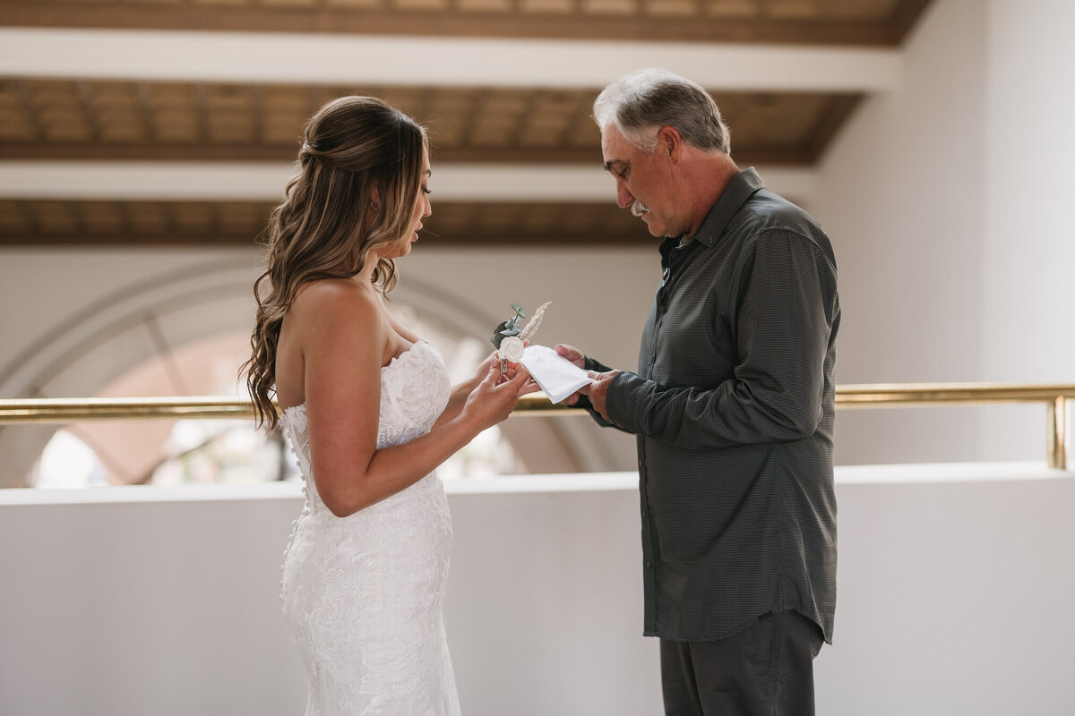 Bride giving dad a gift during first look at Hilton Beachfront Resort Santa Barbara