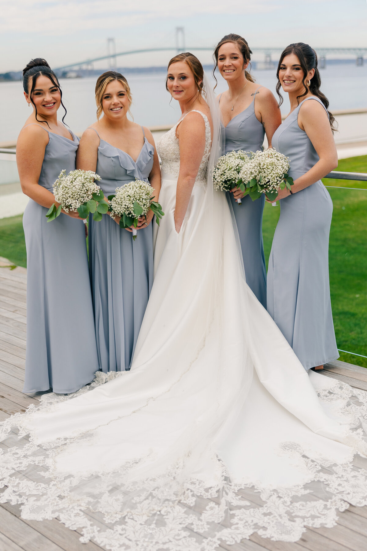 bride with bridesmaids in powder blue with baby's breath florals