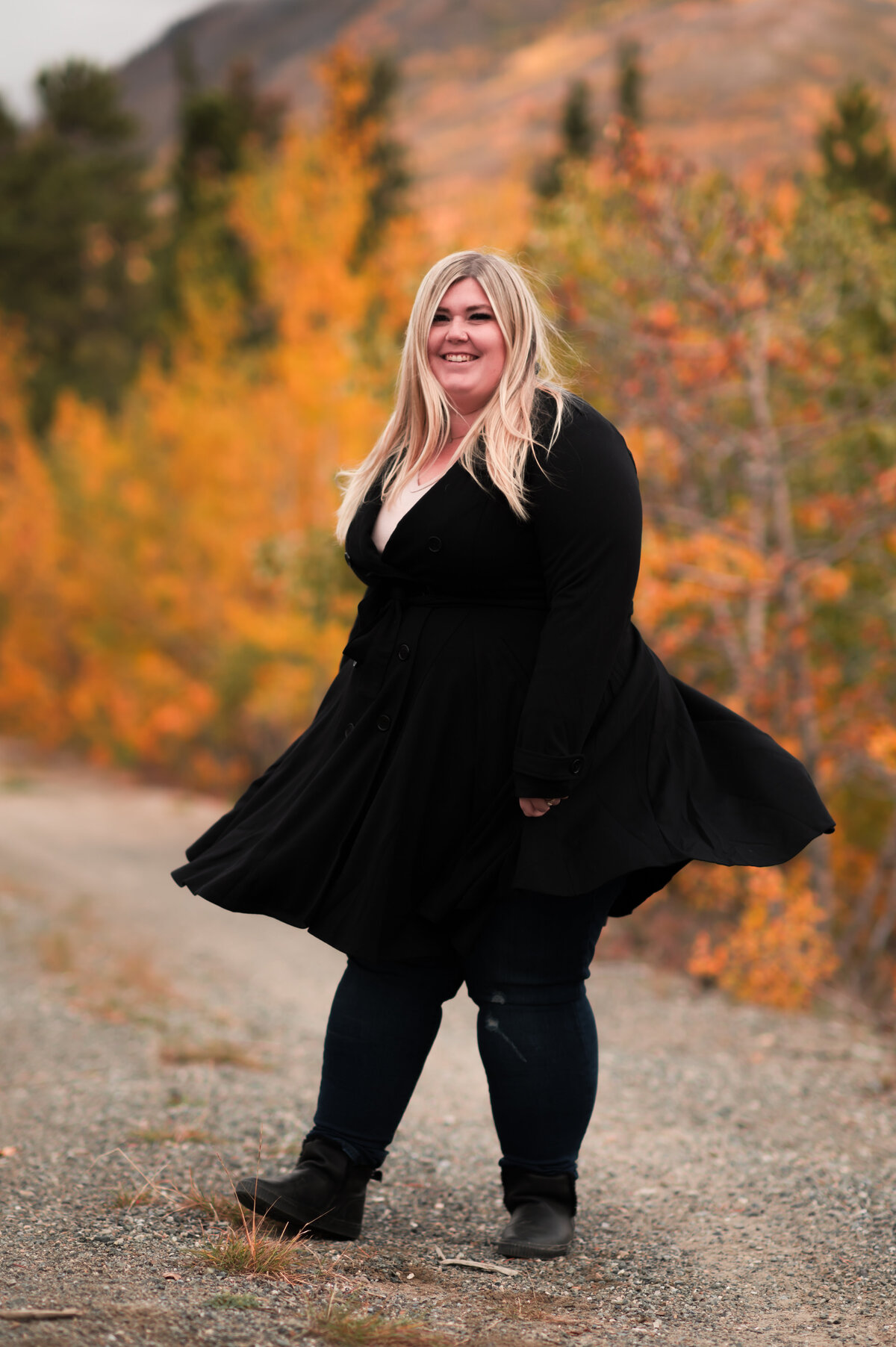 Woman spins on dirt road smiling at camera