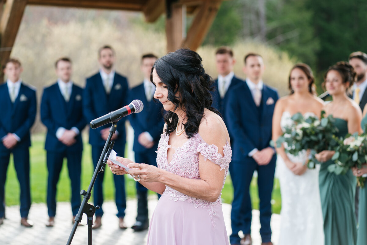 Couple exchanging vows under a floral arch in New England