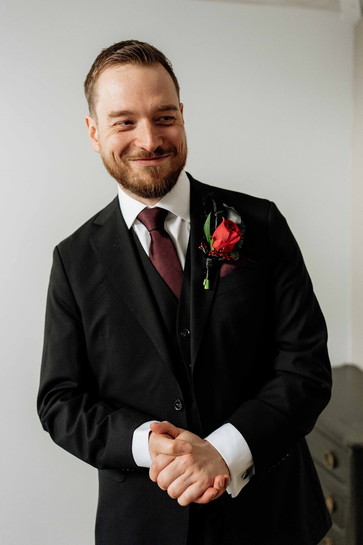 A groom poses candidly for wedding photography portraits. 