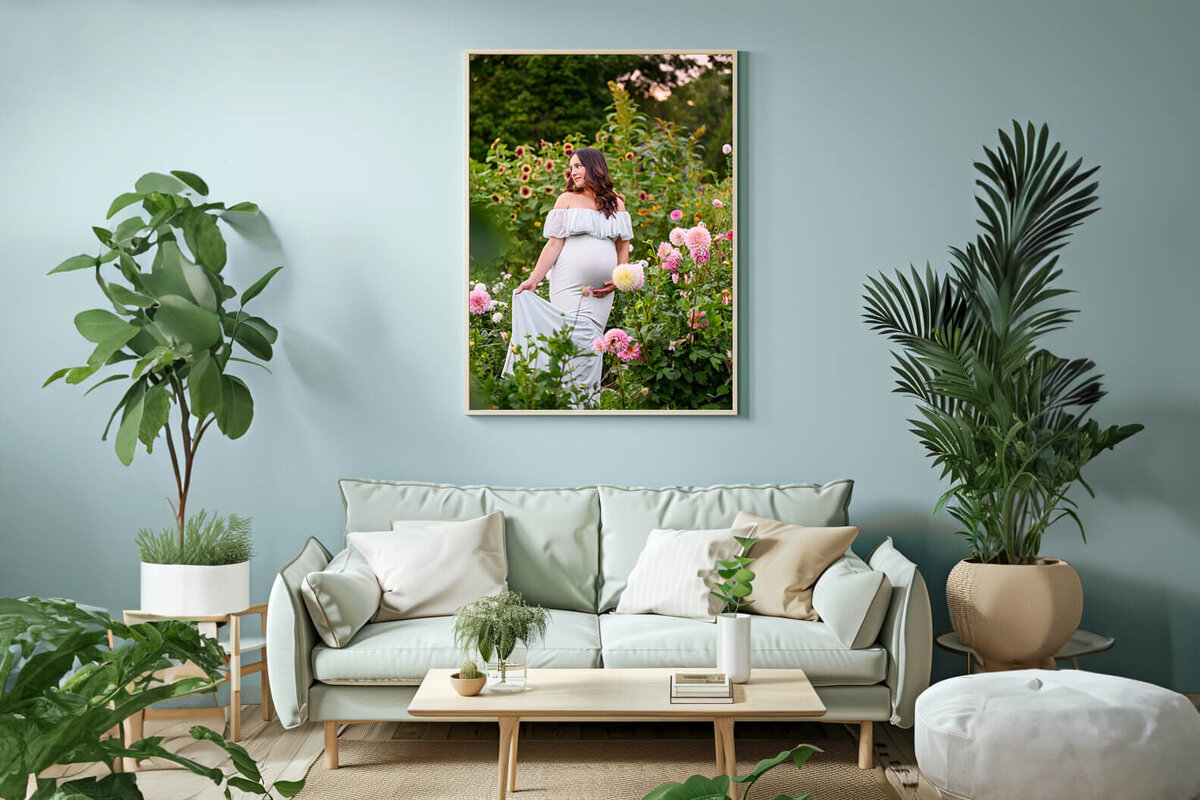 blue room with a framed photo of a woman wearing a mint green dress in a flower field for her summer maternity photography session.