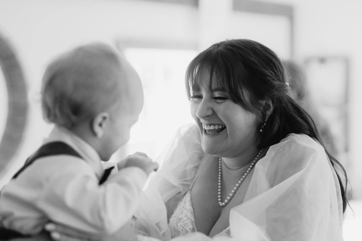 Bride laughing with baby