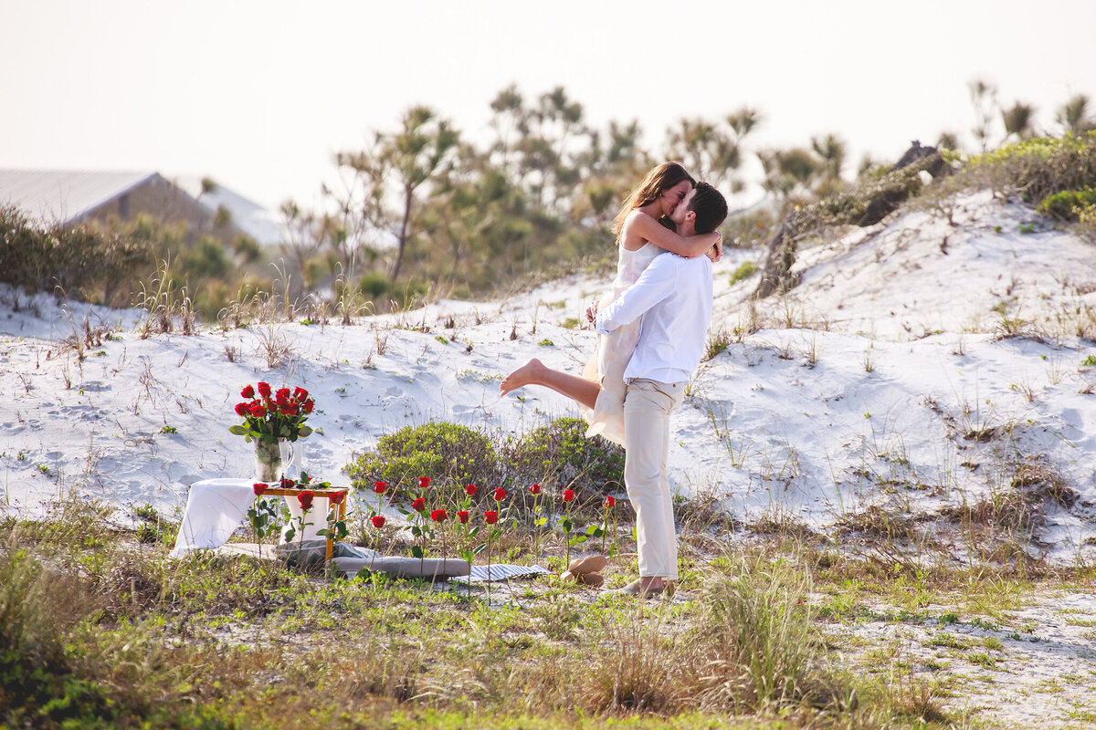 couple embracing after surprise proposal at grayton beach state park.