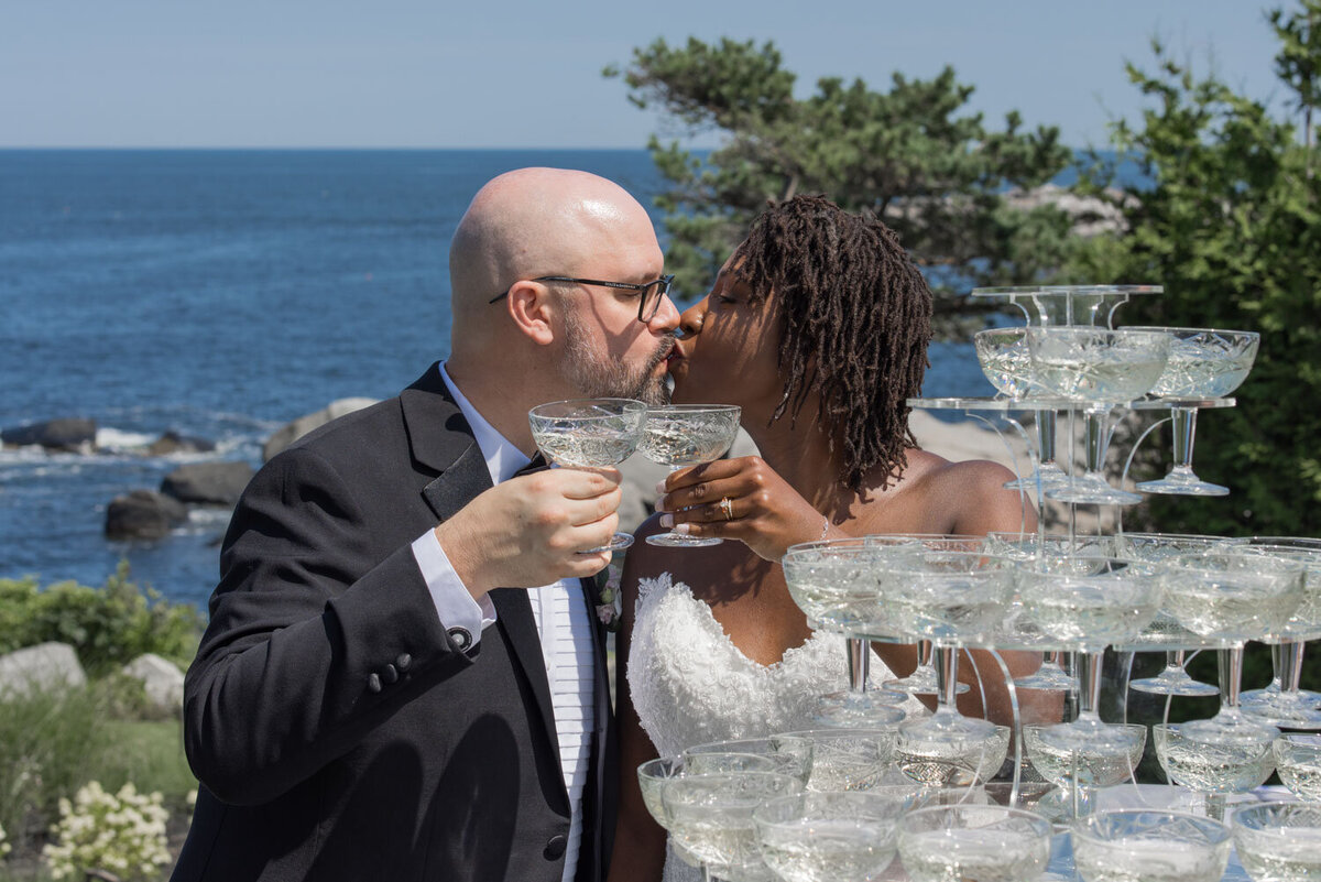 Bride and groom toasting with champagne near the ocean