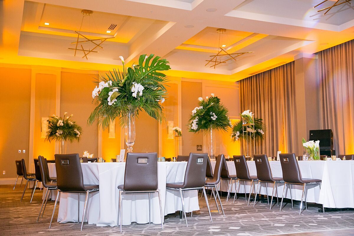 Tall tropical floral centerpieces at a white, green and gold wedding in Nashville