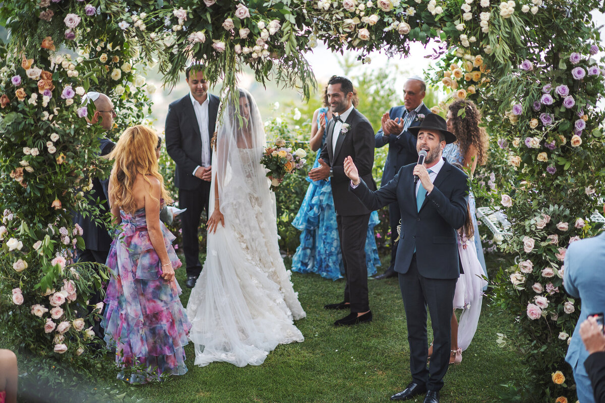 Rabbi is singing in Hebrew at wedding ceremony