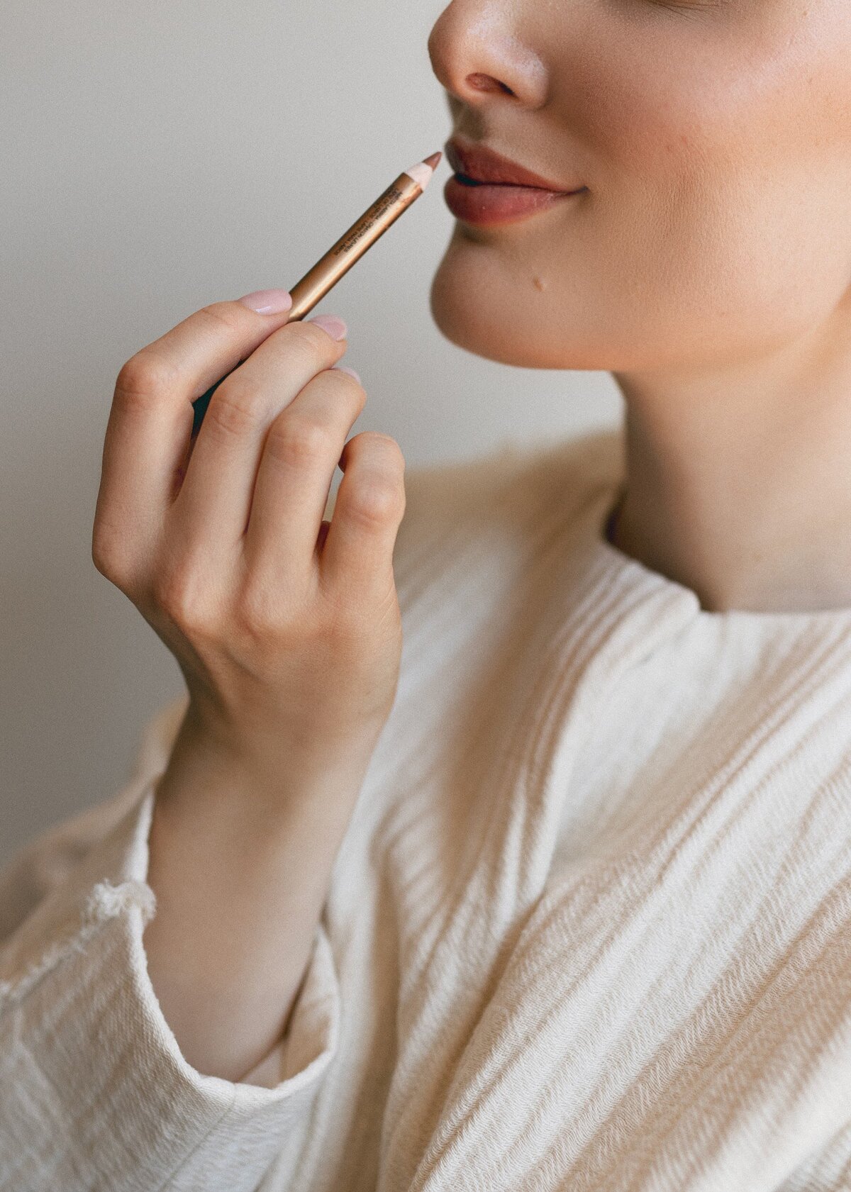 Professional branding photo of Yana holding a makeup brush, representing her bridal beauty studio in San Francisco.