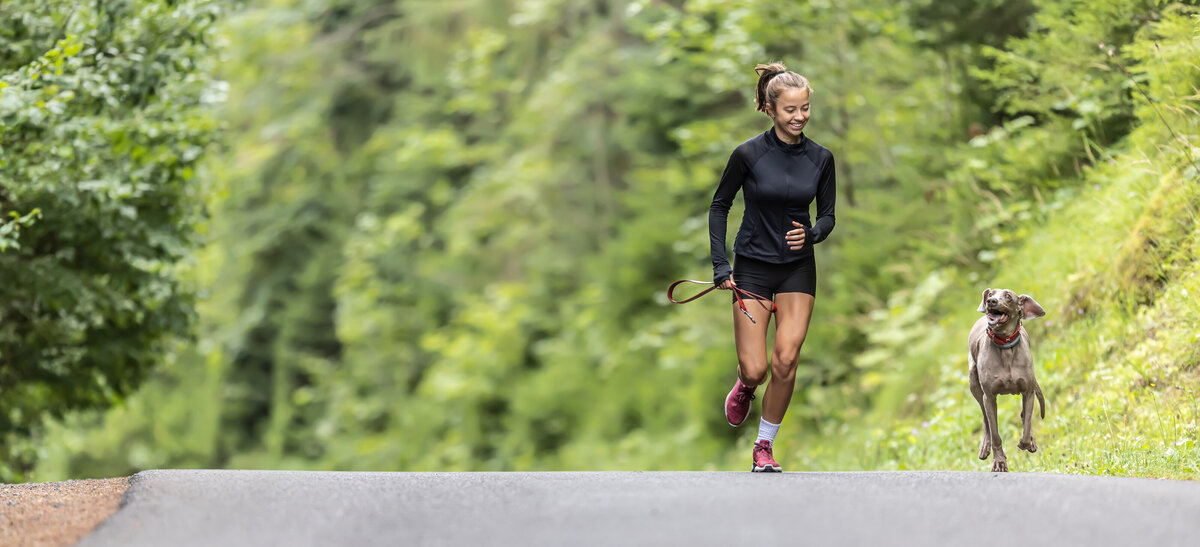 Fit woman running outside with dog 