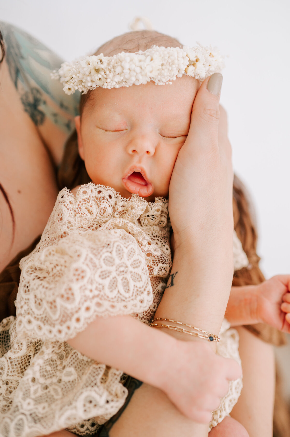 newborn girl hugging mom hand in photography studio in Springfield MO