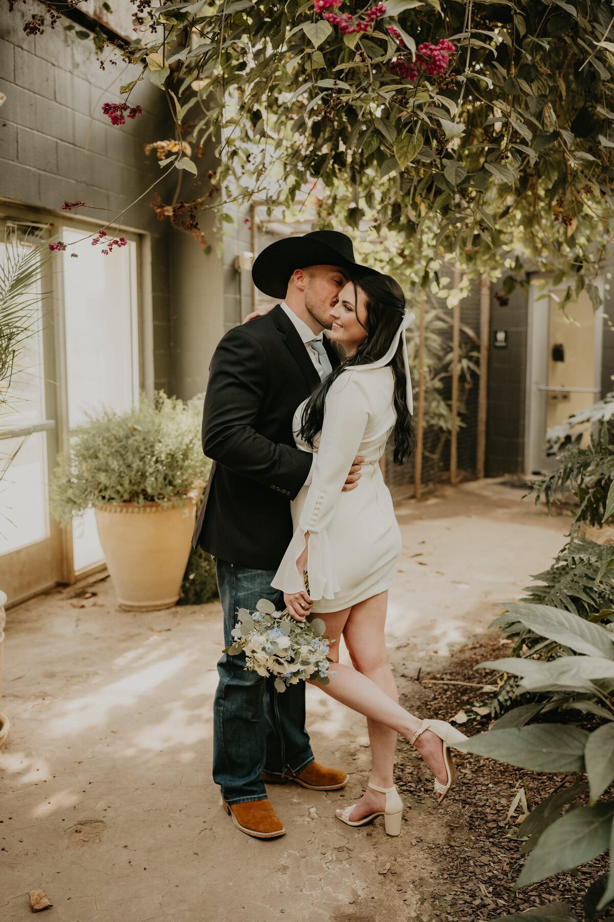 bride and groom kissing and embracing in greenhouse at amarillo botanical gardens