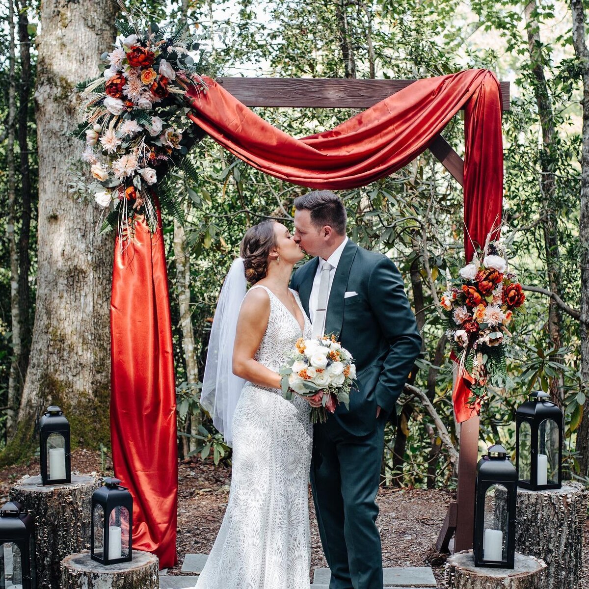 bride and groom kissing under a wooden arch