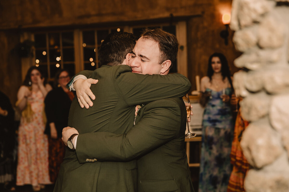 Two people in suits hugging 