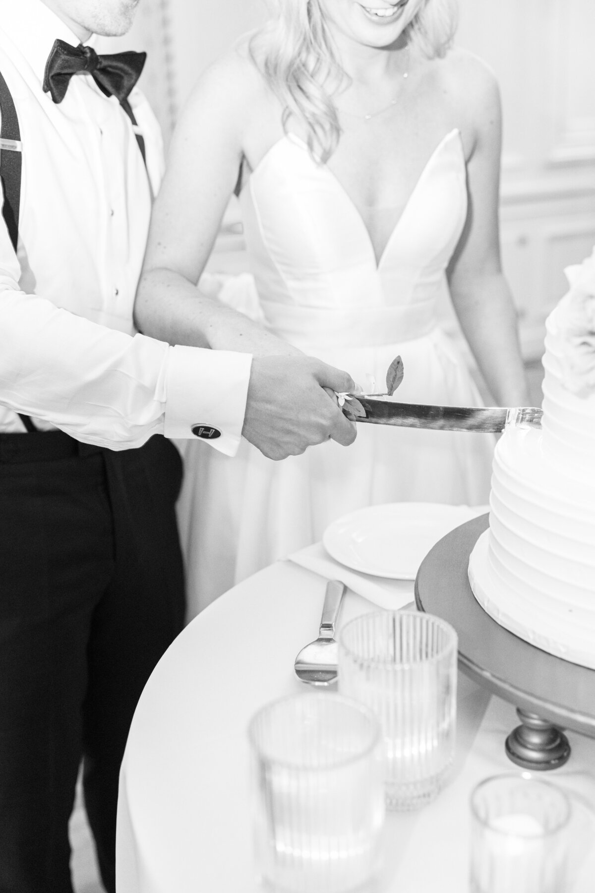 Close up of bride and groom cutting their wedding cake representing candid Boston wedding photography